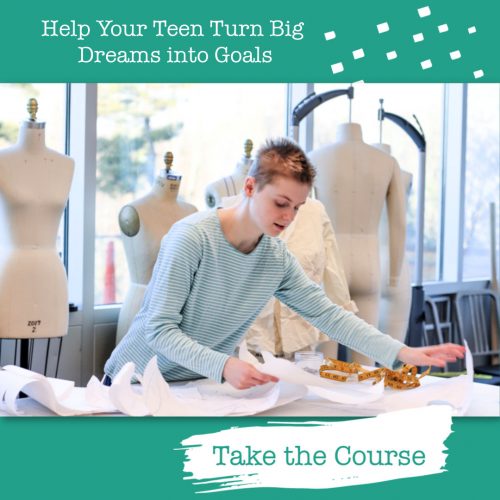 young woman leaning over patterns in a fashion studio with dress forms in the background